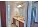 Bathroom featuring a double sink vanity, framed mirror, and view into the tiled shower/tub at 2209 Pecos Ct, Poinciana, FL 34759