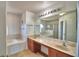 Bright bathroom featuring a double vanity, marble countertops, and a large mirror at 2209 Pecos Ct, Poinciana, FL 34759