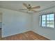 Bedroom with wood laminate flooring, a ceiling fan with a light fixture, and a window with a view at 2209 Pecos Ct, Poinciana, FL 34759