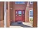 Elegant red front door with glass inserts and a 'welcome' mat, creating a warm and inviting entrance at 2209 Pecos Ct, Poinciana, FL 34759