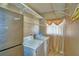 Bright laundry room with washer, dryer, shelving, and a stainless steel refrigerator at 2209 Pecos Ct, Poinciana, FL 34759