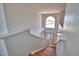 Bright staircase with laminate floors leading to a front door and large window at 2209 Pecos Ct, Poinciana, FL 34759