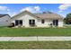 View of the backyard with a patio, seating, and a lush lawn, ideal for outdoor activities and relaxation at 2645 Debany Rd, Kissimmee, FL 34744