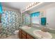 Functional bathroom featuring dual sinks, a large mirror, and a shower with a decorative curtain at 2645 Debany Rd, Kissimmee, FL 34744