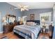 Charming bedroom with wood floors, ceiling fan, blue accent wall, and classic furnishings at 2645 Debany Rd, Kissimmee, FL 34744