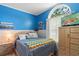 Bright bedroom with blue walls, an arched window, and a comfortable bed and natural light at 2645 Debany Rd, Kissimmee, FL 34744