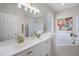 Bright bathroom with white cabinets, double sinks, tub, and stylish decor at 2712 Lido Key Dr, Kissimmee, FL 34747