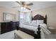 A bright bedroom with a carved wood bed, bench, dresser, mirror and natural light at 2712 Lido Key Dr, Kissimmee, FL 34747