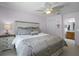 Comfortable bedroom featuring neutral tones, ceiling fan, and soft, patterned bedding at 2712 Lido Key Dr, Kissimmee, FL 34747