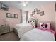 Cozy bedroom with two beds, soft pink walls, and charming decor offering a relaxing retreat at 2712 Lido Key Dr, Kissimmee, FL 34747