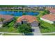 Aerial view of a home with beautiful landscaping and a serene lake backdrop, featuring a tile roof at 2721 Swoop Cir, Kissimmee, FL 34741