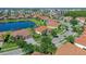 Beautiful aerial view of a home with a tile roof and a large lake nearby in a well-manicured community at 2721 Swoop Cir, Kissimmee, FL 34741