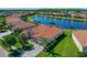 Aerial view of a home with lush landscaping, a lake view, and a paved driveway at 2721 Swoop Cir, Kissimmee, FL 34741