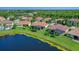 Aerial view highlighting a home's screened-in patio, tile roof, and proximity to a scenic lake at 2721 Swoop Cir, Kissimmee, FL 34741
