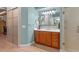Bright bathroom featuring a shower, wood cabinet vanity with a large mirror, and light-toned walls and flooring at 2721 Swoop Cir, Kissimmee, FL 34741