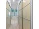 Hallway showing sliding door access to bathroom with soaking tub and bright windows at 2721 Swoop Cir, Kissimmee, FL 34741