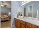 Bathroom view from bedroom featuring a wood cabinet vanity and a large mirror, with light-toned walls and flooring at 2721 Swoop Cir, Kissimmee, FL 34741