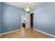 Bright bedroom with pale wood flooring and a view of a powder room featuring a cherry vanity at 2721 Swoop Cir, Kissimmee, FL 34741