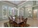Formal dining room with elegant chandelier, a large table, and white plantation shutters at 2721 Swoop Cir, Kissimmee, FL 34741