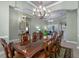 Formal dining room offering an elegant chandelier, a large table, and a view to the living room at 2721 Swoop Cir, Kissimmee, FL 34741