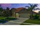 Beautiful single-story home showcasing tile roof and a well-manicured lawn with a decorative palm tree at 2721 Swoop Cir, Kissimmee, FL 34741