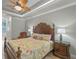 Main bedroom featuring tray ceiling, wood-look floors, and decorative furniture at 2721 Swoop Cir, Kissimmee, FL 34741