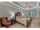 Main bedroom with tray ceiling, ceiling fan, wood-look floors, and decorative furniture at 2721 Swoop Cir, Kissimmee, FL 34741