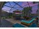 Relaxing screened patio with view of a lake, complete with lounge seating and dining area at 2721 Swoop Cir, Kissimmee, FL 34741