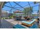 Outdoor lanai with dining and lounging furniture, overlooking the serene lake, enhanced by an overhead screen at 2721 Swoop Cir, Kissimmee, FL 34741
