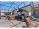 Outdoor lanai with a hot tub, grill, and seating area, offering a relaxing and entertaining outdoor space at 2721 Swoop Cir, Kissimmee, FL 34741