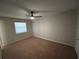 This bedroom has neutral walls, carpet, and a window with a ceiling fan for comfortable living at 2813 Calico Ct, Orlando, FL 32822