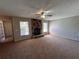 Cozy living room with a stone fireplace, carpet flooring, and windows for natural lighting at 2813 Calico Ct, Orlando, FL 32822