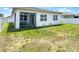 The backyard features a lawn area, screened lanai, and white fence for privacy at 308 Buchannan Dr, Davenport, FL 33837