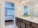 Bathroom features a double vanity with quartz countertops, dark wood cabinets, and modern fixtures at 308 Buchannan Dr, Davenport, FL 33837