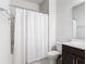 Bright bathroom featuring a clean white shower curtain, toilet, and well-lit vanity area at 308 Buchannan Dr, Davenport, FL 33837