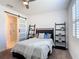 Cozy bedroom with barn door to bathroom, ceiling fan, and minimalist decor at 308 Buchannan Dr, Davenport, FL 33837