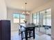 Bright dining area featuring a modern chandelier, bench seating, and sliding glass doors to the patio at 308 Buchannan Dr, Davenport, FL 33837