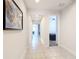 Bright hallway with neutral tile and artwork leading to rooms with natural light and ceiling fans at 308 Buchannan Dr, Davenport, FL 33837