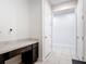 Bright hallway featuring a built-in desk, neutral tile flooring, and crisp white walls at 308 Buchannan Dr, Davenport, FL 33837