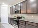 Well-equipped kitchen featuring stainless steel appliances, gray subway tile backsplash, and granite countertops at 308 Buchannan Dr, Davenport, FL 33837