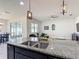 Stylish kitchen island featuring granite countertops, pendant lighting, and stainless steel sink at 308 Buchannan Dr, Davenport, FL 33837