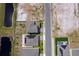 An aerial view of two homes with solar panels, a pond, and vacant lots at 3134 Viceroy Ct, Poinciana, FL 34759