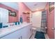 Bathroom featuring a vanity with drawers, a bathtub, a shower with a blue and white striped curtain, and peach colored walls at 3134 Viceroy Ct, Poinciana, FL 34759