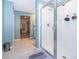 Modern bathroom featuring a glass-enclosed shower, tile floors, and a doorway to the walk-in closet at 3134 Viceroy Ct, Poinciana, FL 34759