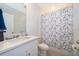 Bright bathroom with a white vanity, tiled floors, and a bathtub with a butterfly-themed shower curtain at 3134 Viceroy Ct, Poinciana, FL 34759