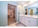Bathroom featuring double sinks, white cabinets, tile flooring, and an open entrance to a large walk-in closet at 3134 Viceroy Ct, Poinciana, FL 34759
