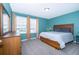 Bright bedroom featuring carpet floors, a light fixture and a wooden bed frame with two windows letting in natural light at 3134 Viceroy Ct, Poinciana, FL 34759