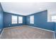 Large bonus room featuring carpeted floors, blue walls, and natural light at 3134 Viceroy Ct, Poinciana, FL 34759