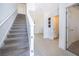 Bright entryway with staircase and tile flooring, leading to a half-bathroom and living spaces at 3134 Viceroy Ct, Poinciana, FL 34759