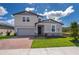 Two-story home showcasing a brick driveway, well-manicured lawn, and welcoming front entry at 3134 Viceroy Ct, Poinciana, FL 34759